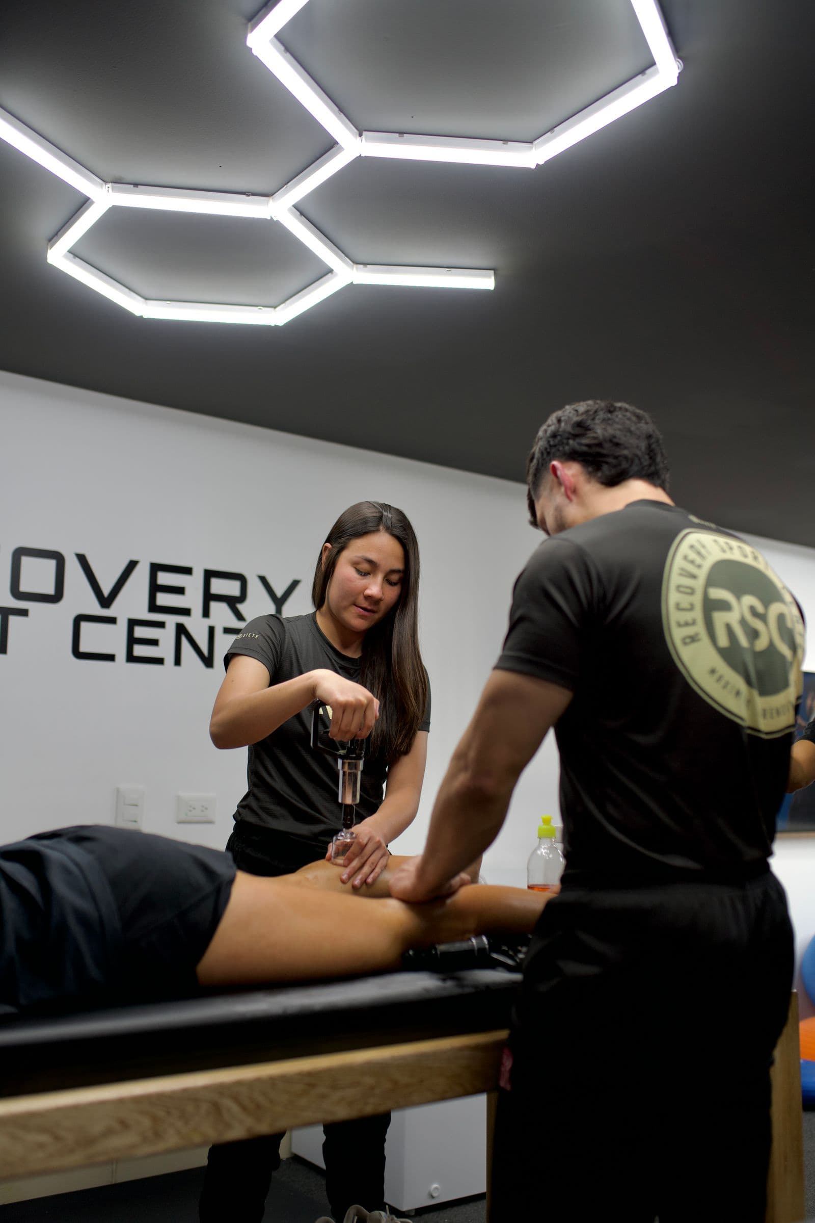 Dos fisioterapeutas tratando a un paciente en una clínica moderna
