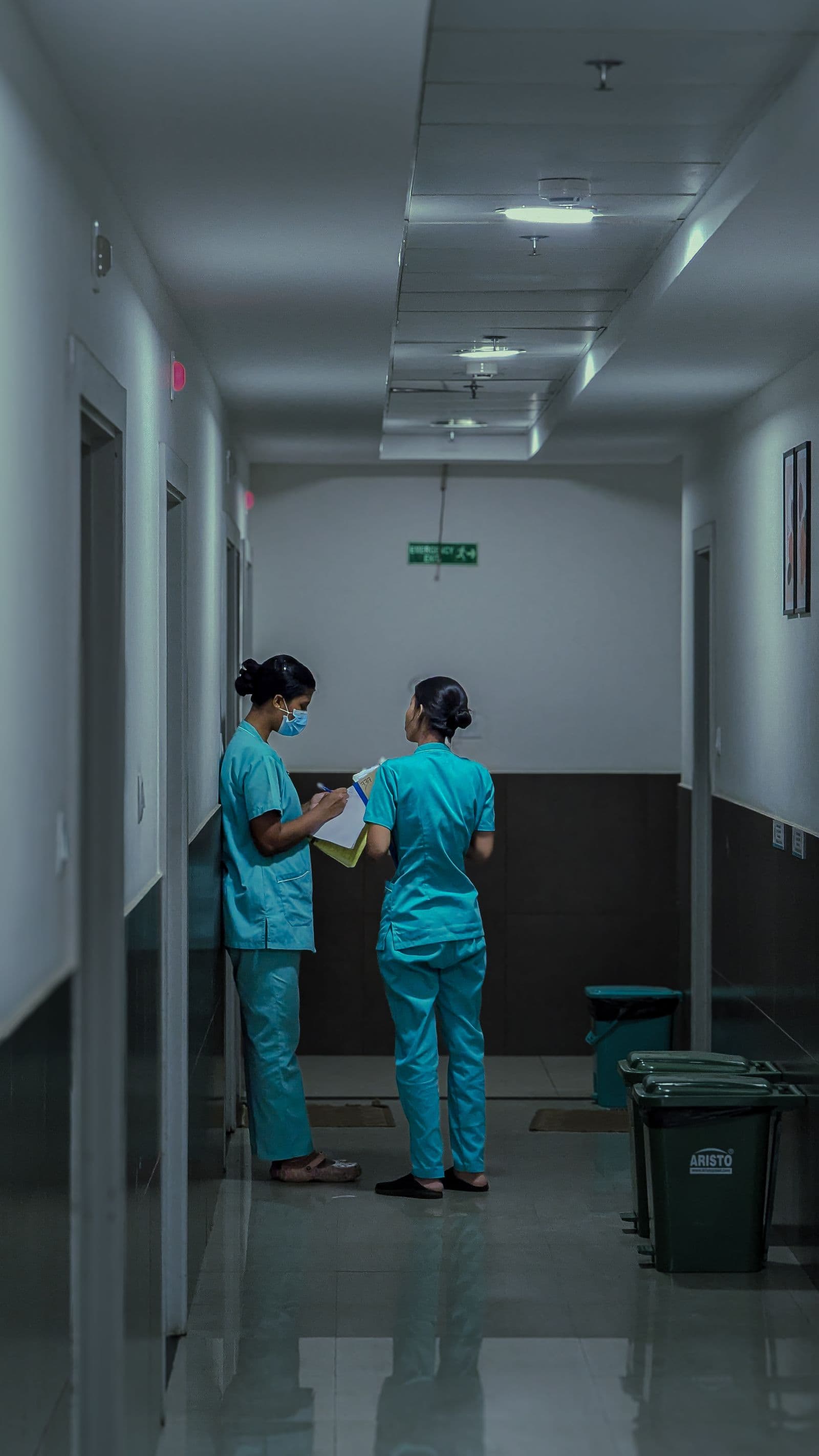 Dos profesionales sanitarias comentando notas de un paciente