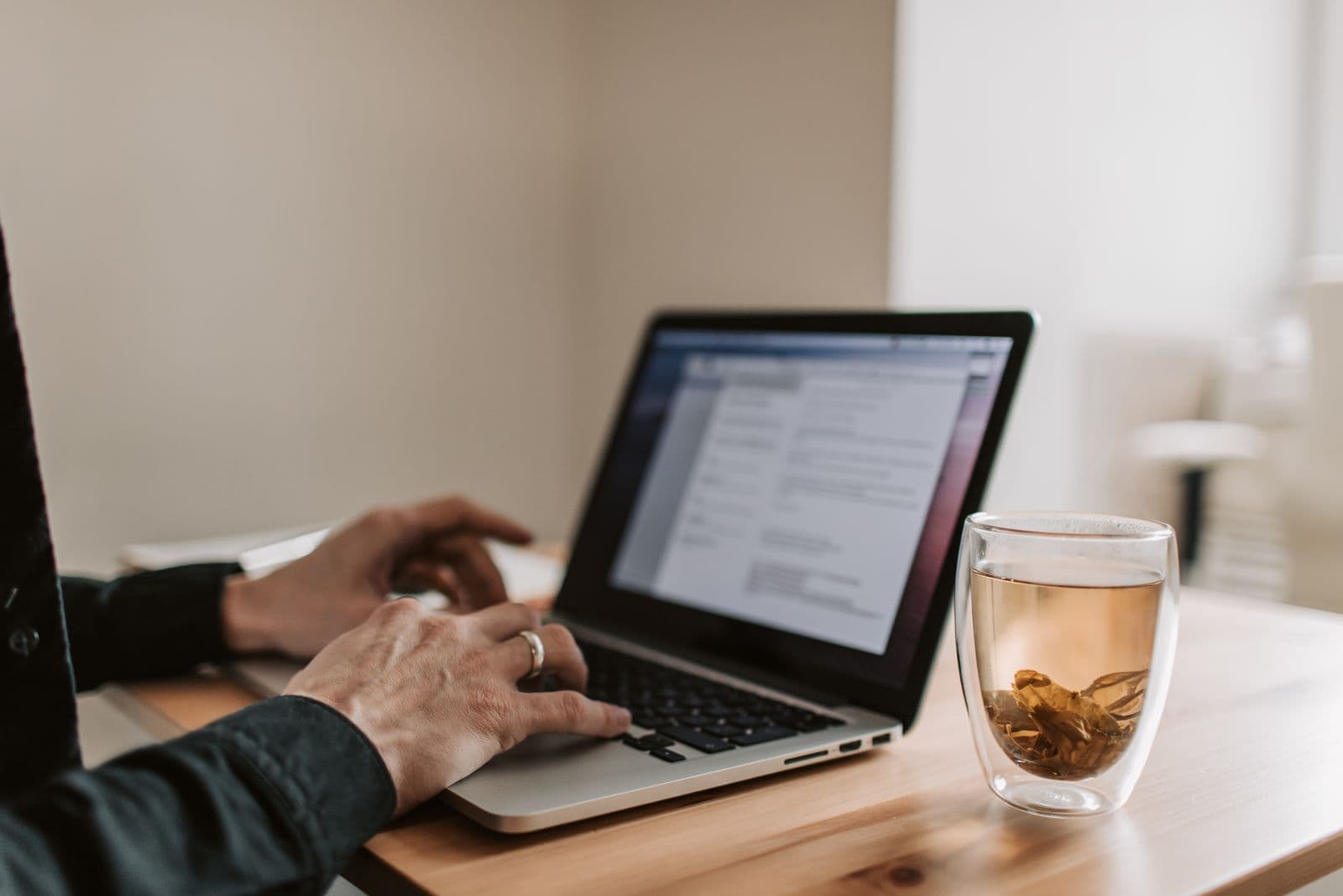 Persona trabajando con un portátil y una taza de té