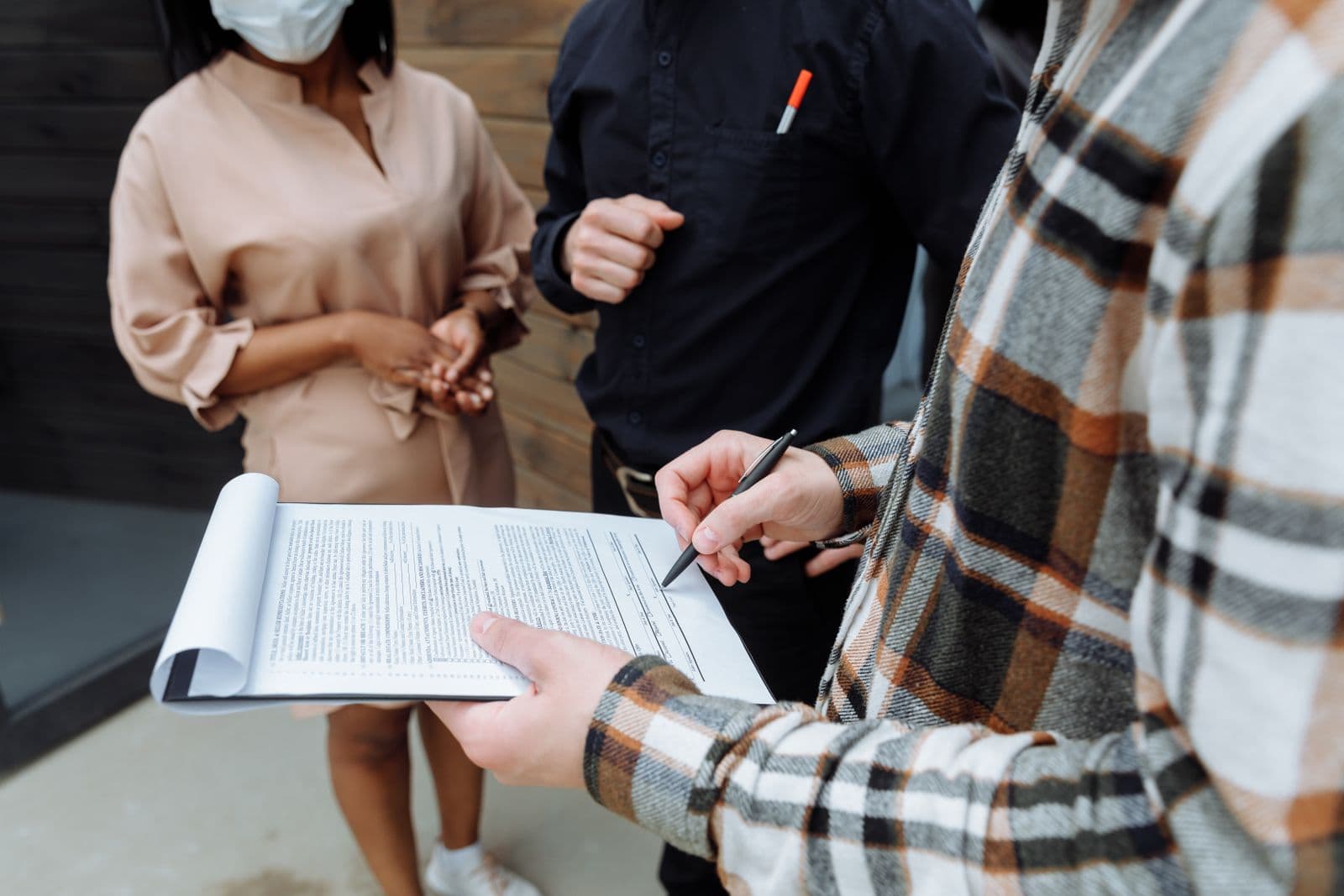 Tres personas revisando y firmando un documento en una oficina
